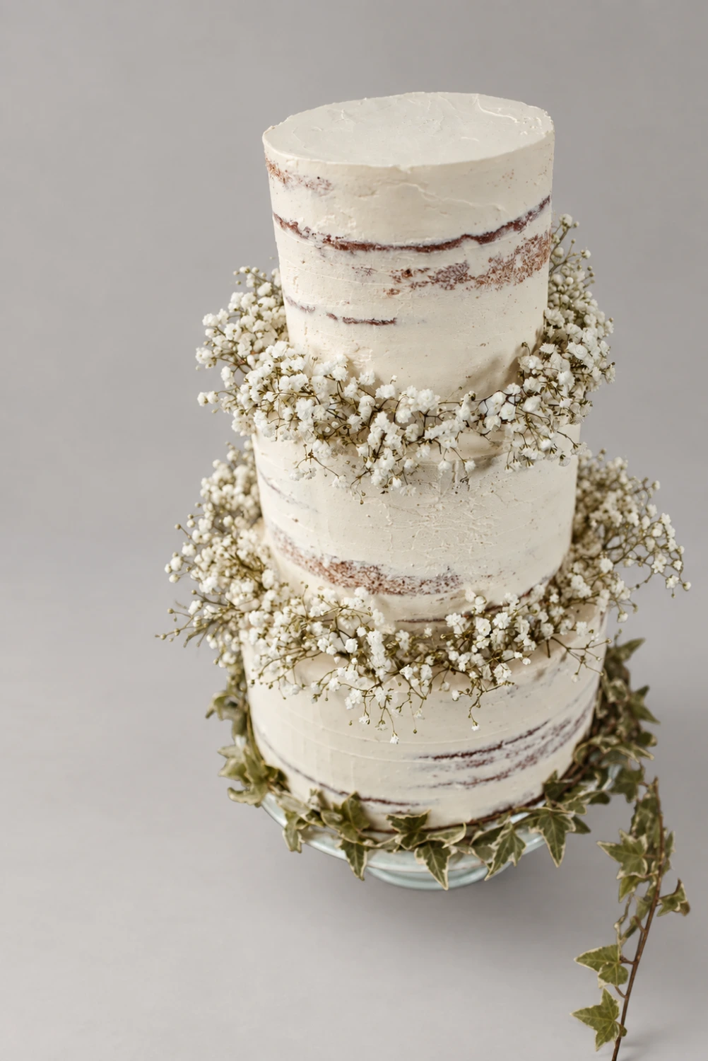 Three-tier semi-naked cake with white gypsophila garlands