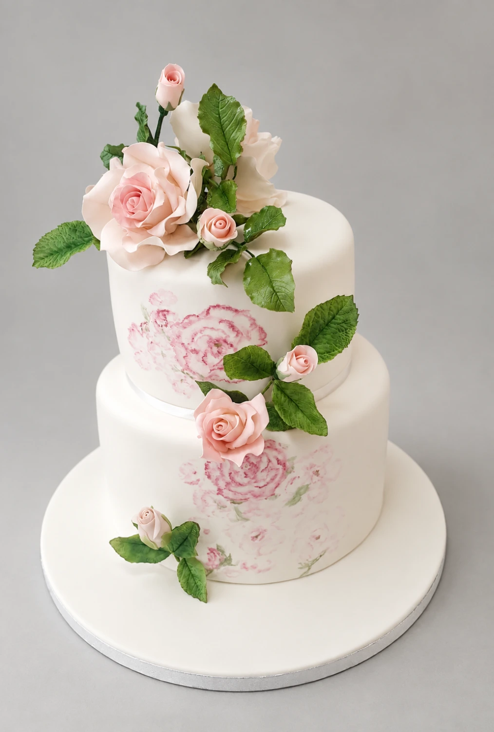 Two-tier ivory cake with painted pink flowers, modeled roses and green leaves