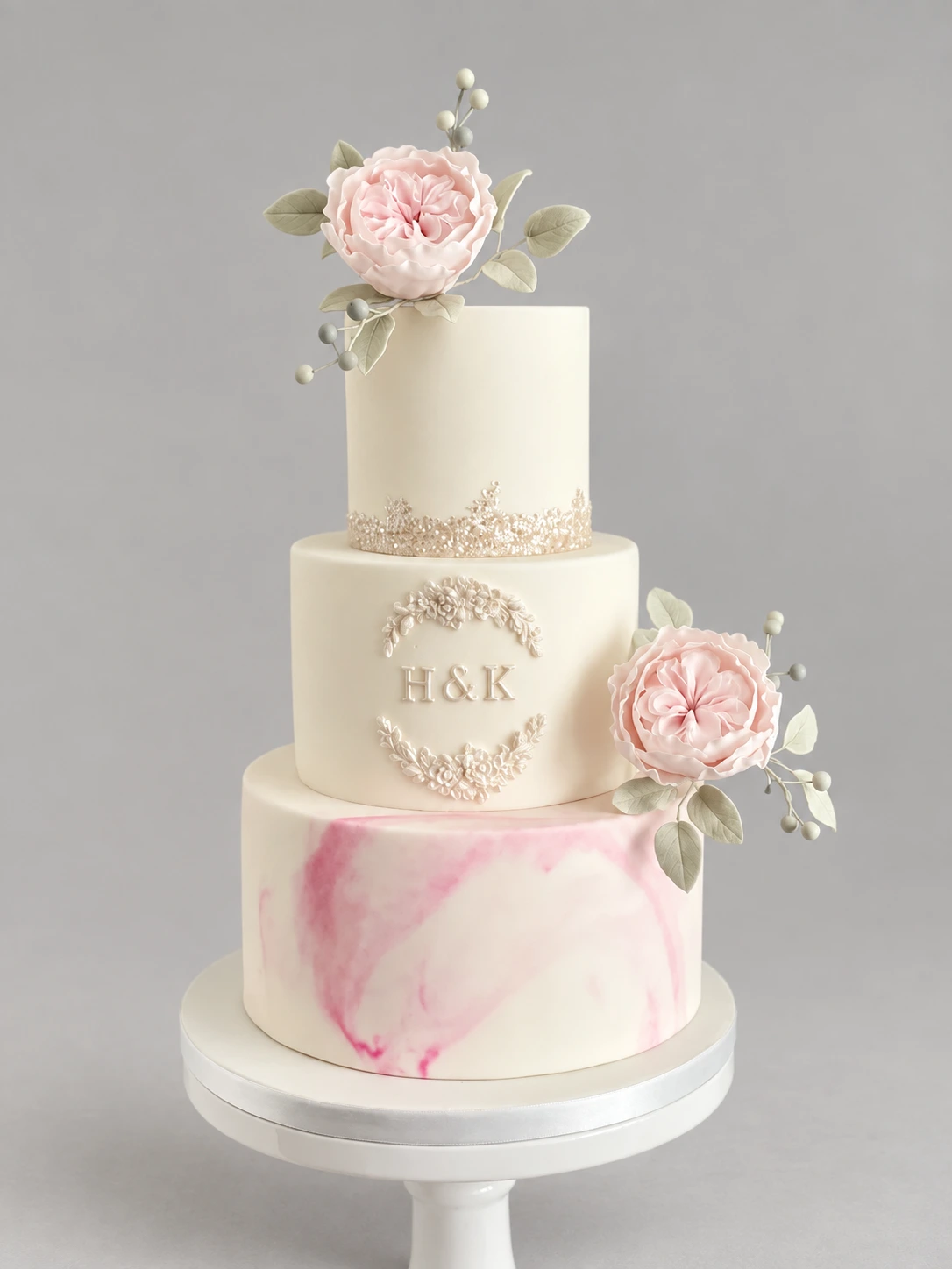 Three-tier ivory cake with a pink marble base, pale pink sugar roses and pearl details