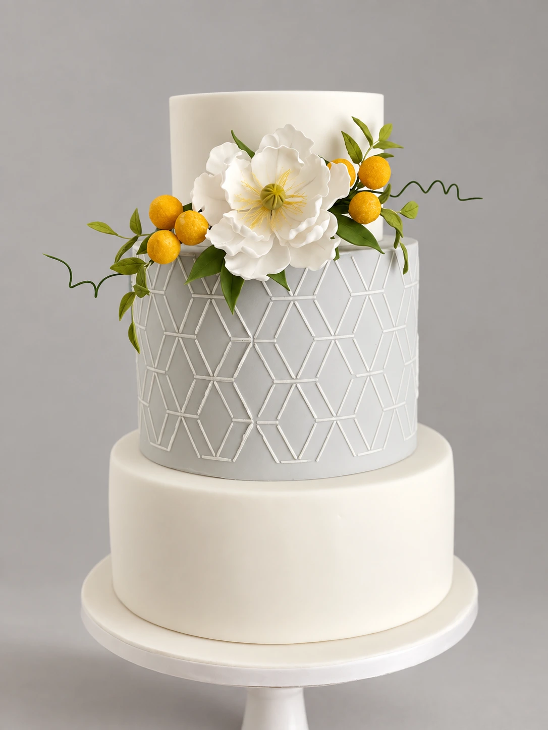 Two-tier ivory and pale grey cake with geometric lattice and a large white sugar peony