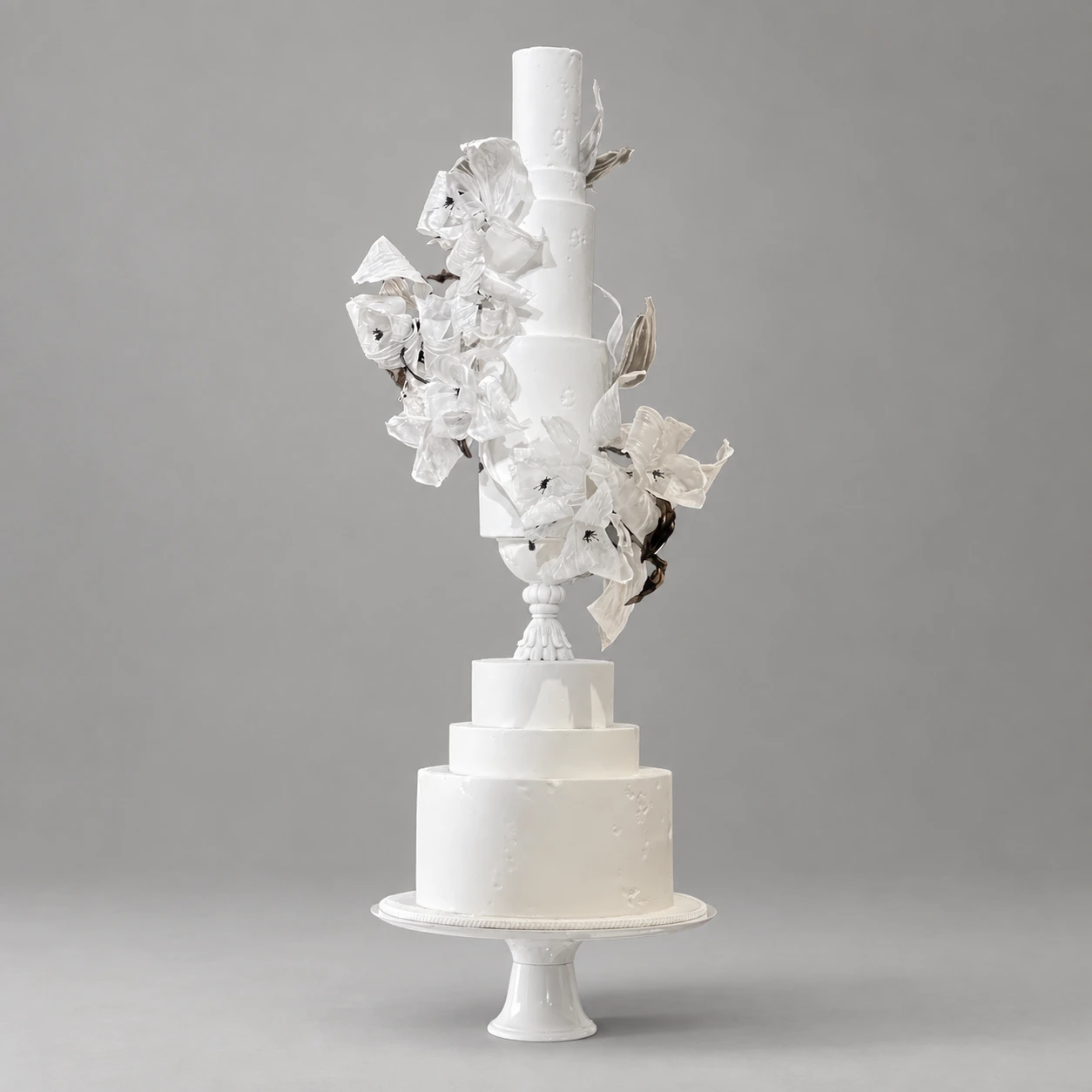 Six-tier ivory cake with a central ornamental column and clouds of translucent white blossoms