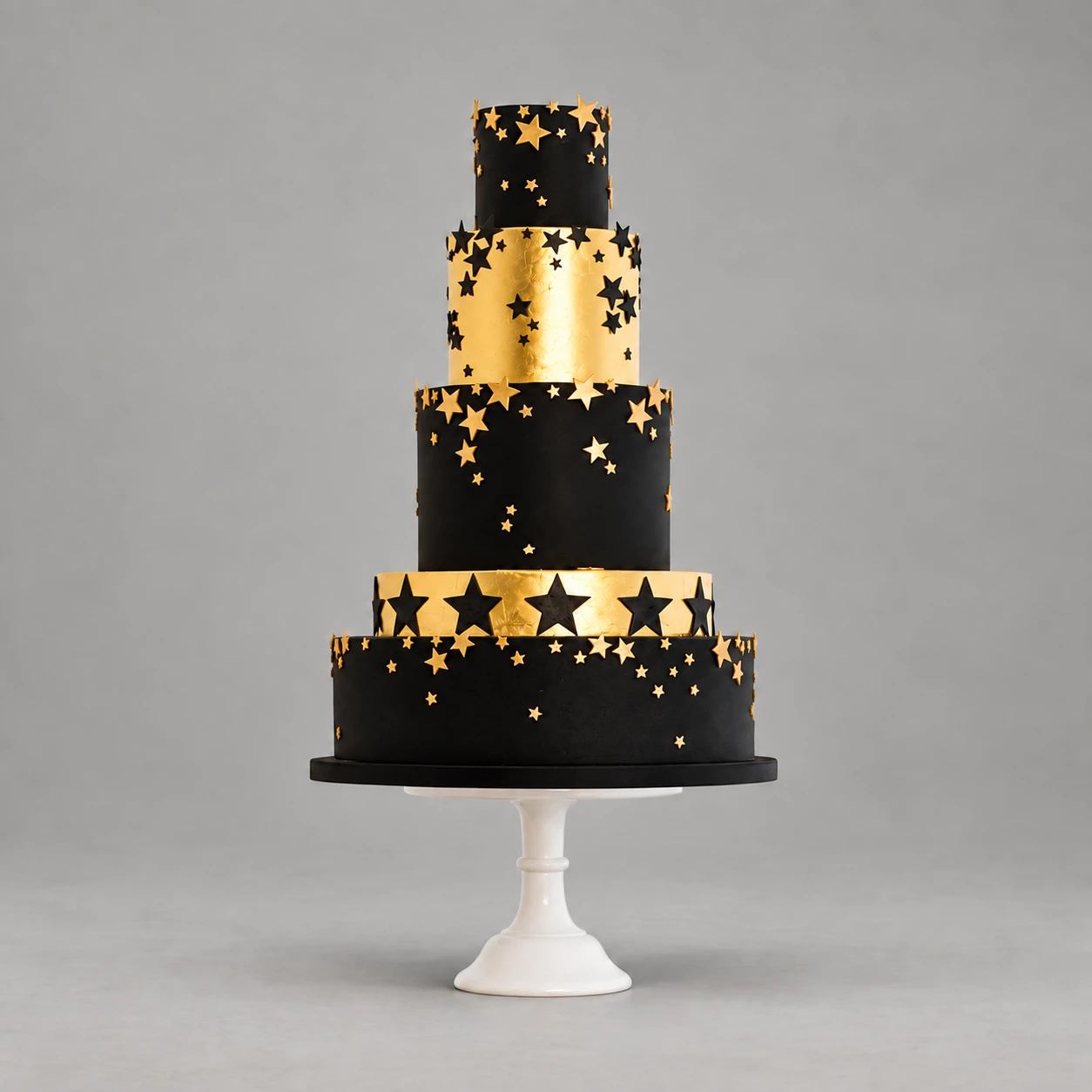 Five-tier black and gold cake decorated with cascading gold and black stars
