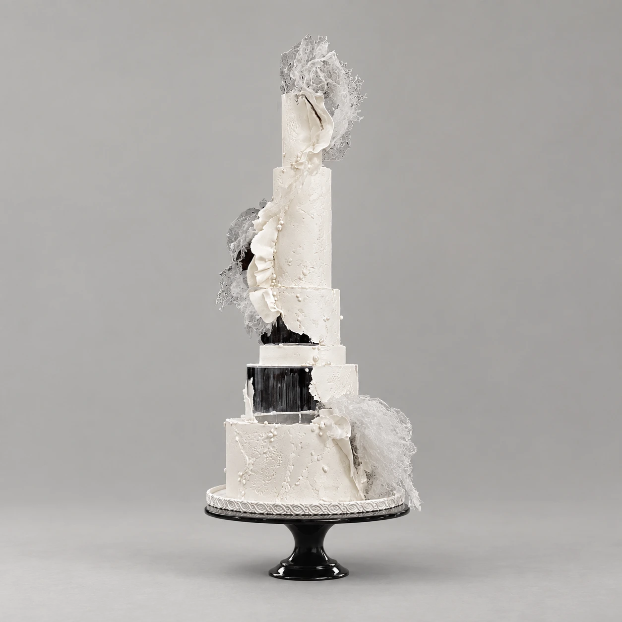 Six-tier black and ivory cake with pearl details, silver separators and translucent lace-like sails