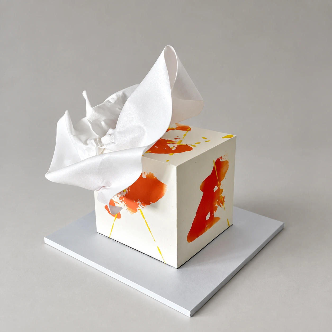 Single-tier square cake with ivory and citrus brushstrokes and a white folded sail