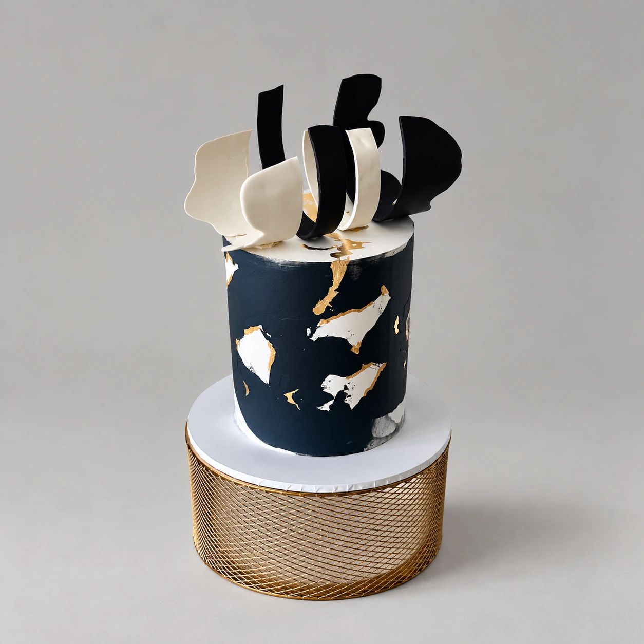 Single-tier navy and ivory cake with gold lines and black and white chocolate sails